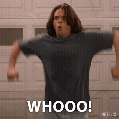 A Man Is Standing In Front Of A Garage Door With His Arms Outstretched And The Words Whooo Written On His Shirt . GIF