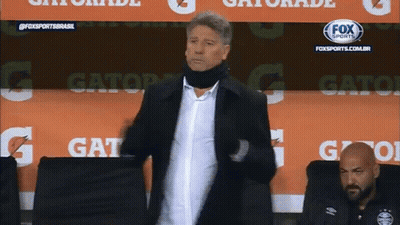 A Man Is Standing In Front Of A Gatorade Advertisement GIF