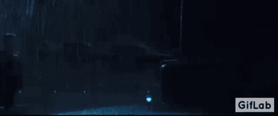 A Man Is Standing In Front Of A Giant Monster In A Dark Room With A Giflab Logo In The Corner GIF