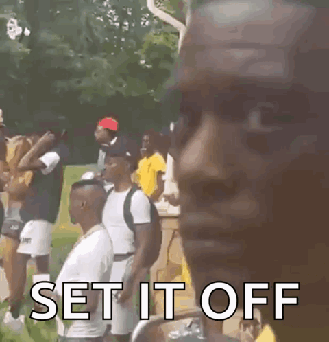 A Man Is Standing In Front Of A Group Of People And Says `` Set It Off '' GIF