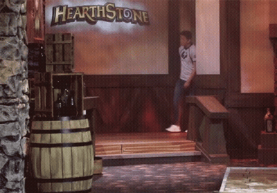 A Man Is Standing In Front Of A Hearthstone Sign GIF