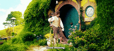 A Man Is Standing In Front Of A House With A Green Door . GIF