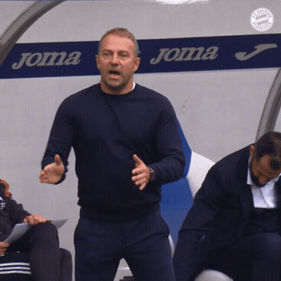 A Man Is Standing In Front Of A Joma Sign GIF