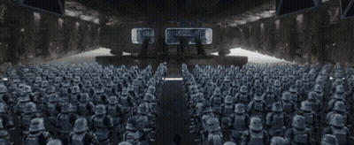 A Man Is Standing In Front Of A Large Group Of Stormtroopers GIF