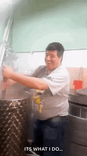 A Man Is Standing In Front Of A Large Pot In A Kitchen And Says It 'S What I Do . GIF