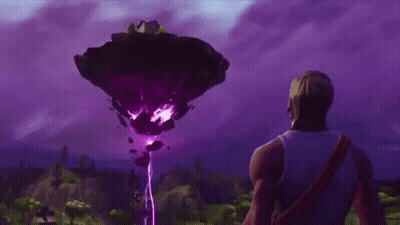 A Man Is Standing In Front Of A Large Purple Object In The Sky . GIF