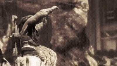 A Man Is Standing In Front Of A Large Rock In A Dark Room . GIF