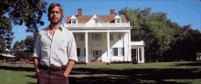 A Man Is Standing In Front Of A Large White House GIF