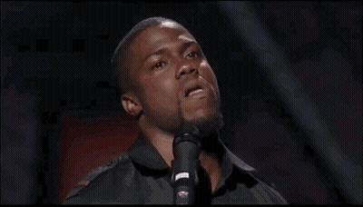 A Man Is Standing In Front Of A Microphone And Singing Into It . GIF