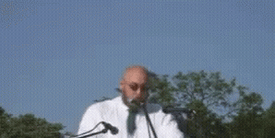 A Man Is Standing In Front Of A Microphone With The Words `` Enough Is Enough '' Written On It . GIF