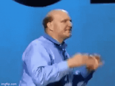 A Man Is Standing In Front Of A Microsoft Windows Logo GIF