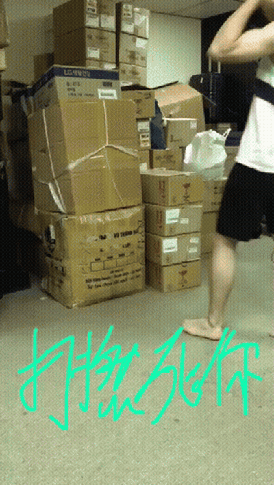 A Man Is Standing In Front Of A Pile Of Boxes With The Word Lg On Them GIF