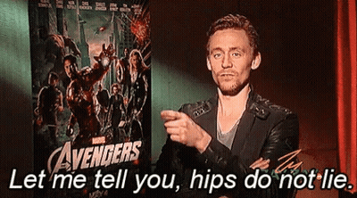 A Man Is Standing In Front Of A Poster For The Avengers GIF