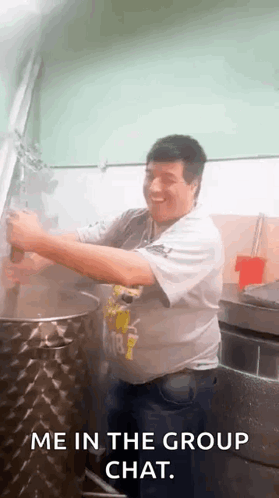 A Man Is Standing In Front Of A Pot In A Kitchen With The Words `` Me In The Group Chat '' Written Below Him . GIF