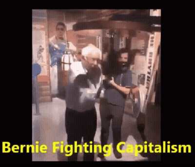 A Man Is Standing In Front Of A Punching Bag With The Words `` Bernie Fighting Capitalism '' . GIF