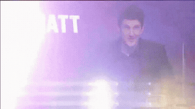 A Man Is Standing In Front Of A Purple Background With The Word Matt In White Letters GIF