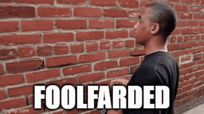 A Man Is Standing In Front Of A Red Brick Wall With The Words Foolfarded On It . GIF