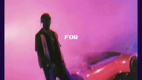 A Man Is Standing In Front Of A Red Car With The Words `` For '' Written Above Him . GIF