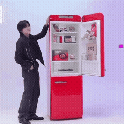 A Man Is Standing In Front Of A Red Refrigerator That Has The Door Open GIF