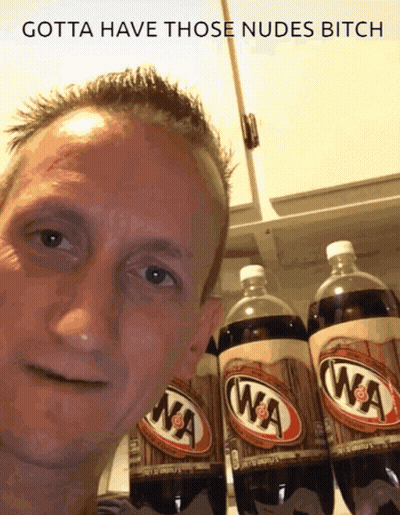 A Man Is Standing In Front Of A Row Of Wa Cola Bottles GIF