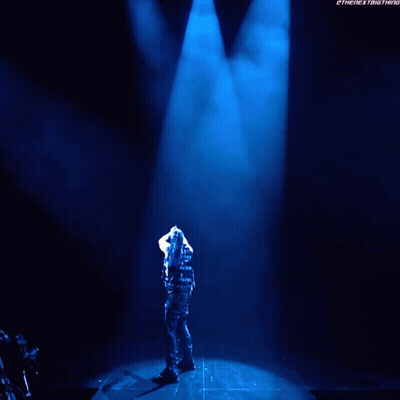 A Man Is Standing In Front Of A Sign That Says Damian Presley GIF