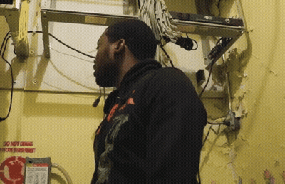 A Man Is Standing In Front Of A Sign That Says " Do Not Drink " GIF