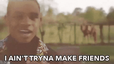 A Man Is Standing In Front Of A Sign That Says I Ain 'T Tryna Make Friends GIF