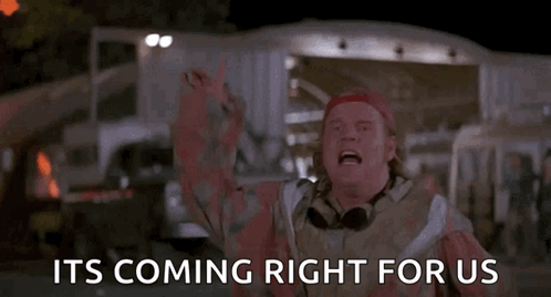 A Man Is Standing In Front Of A Sign That Says `` It 'S Coming Right For Us '' GIF