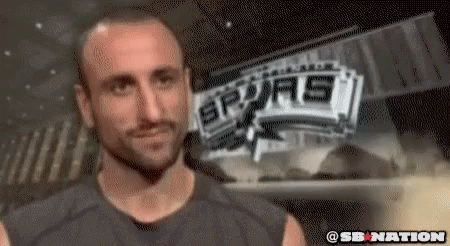 A Man Is Standing In Front Of A Sign That Says Spurs GIF