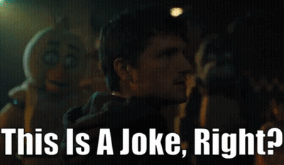 A Man Is Standing In Front Of A Sign That Says " This Is A Joke Right " GIF