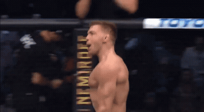 A Man Is Standing In Front Of A Sign That Says ' Ufc ' On It . GIF