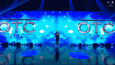 A Man Is Standing In Front Of A Stage That Says Otc On It GIF