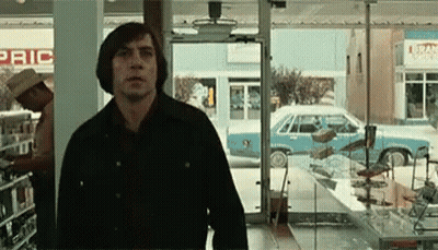 A Man Is Standing In Front Of A Store That Has The Word Pric On It GIF