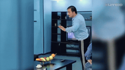 A Man Is Standing In Front Of A Table With A Bowl Of Fruit On It .. GIF