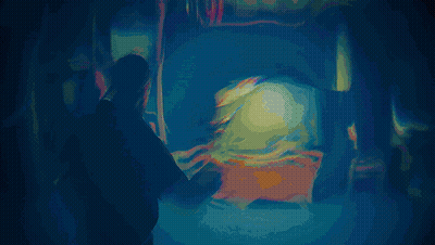 A Man Is Standing In Front Of A Television With A Glowing Light On It GIF