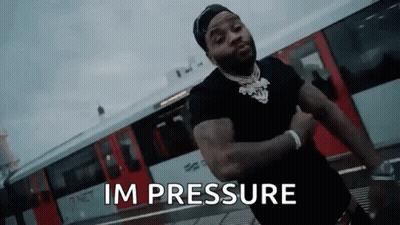A Man Is Standing In Front Of A Train With His Arms Crossed And The Words `` Im Pressure '' Written On The Screen . GIF