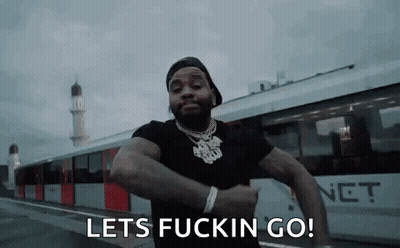 A Man Is Standing In Front Of A Train With The Words `` Lets Fuckin Go '' Written On His Face . GIF