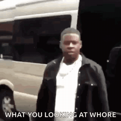 A Man Is Standing In Front Of A Van And Looking At The Camera . GIF
