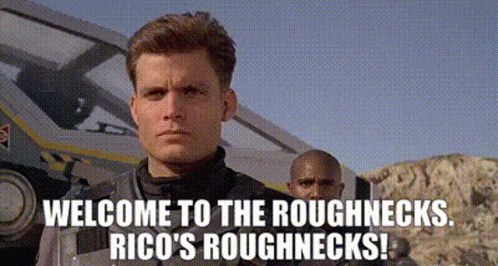 A Man Is Standing In Front Of A Vehicle With The Words Welcome To The Roughnecks Rico 'S Roughnecks Written Below Him GIF