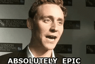 A Man Is Standing In Front Of A Wall That Says Absolutely Epic GIF