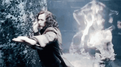 A Man Is Standing In Front Of A Wall With Flames Coming Out Of It And Talking On A Cell Phone . GIF