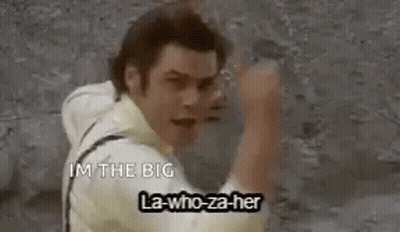 A Man Is Standing In Front Of A Wall With His Fist In The Air And Says `` I 'M The Big '' . GIF