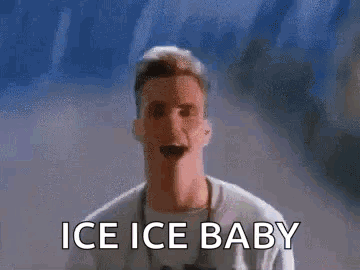 A Man Is Standing In Front Of A Wall With The Words `` Ice Ice Baby '' On It . GIF