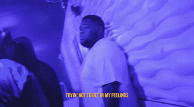 A Man Is Standing In Front Of A Wall With The Words Tryin ' Not To Get In My Feelings On The Bottom GIF