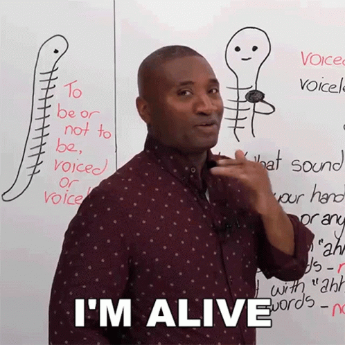 A Man Is Standing In Front Of A White Board With A Drawing Of A Skeleton And The Words I 'M Alive GIF