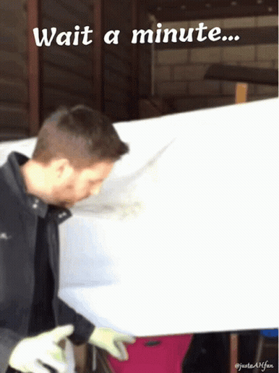 A Man Is Standing In Front Of A White Board With The Words Wait A Minute Below Him GIF