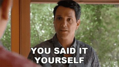 A Man Is Standing In Front Of A Window And Talking To Another Man . GIF
