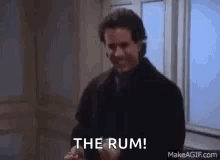 A Man Is Standing In Front Of A Window Holding A Bottle Of Rum And Saying `` The Rum '' . GIF