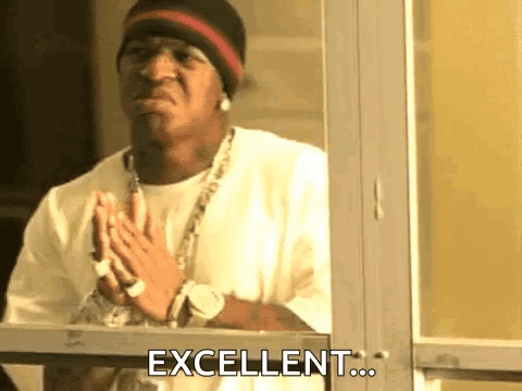 A Man Is Standing In Front Of A Window With His Hands Folded And The Words `` Excellent '' Written On The Window . GIF