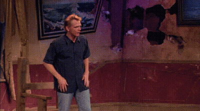 A Man Is Standing In Front Of A Window With His Hands Outstretched And Says Hey GIF
